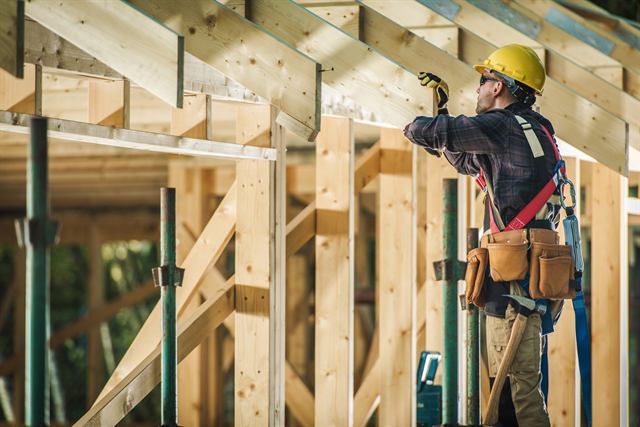 Builder working on the framing of a room addition