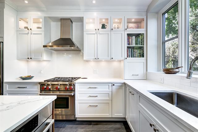 Remodeled kitchen with white cabinets and a marble counter
