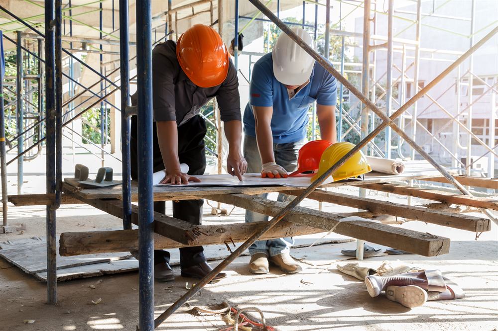 Builders reviewing plans on site